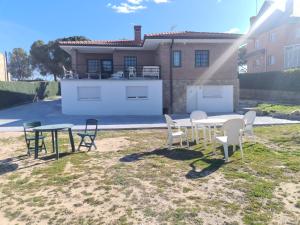 een tafel en stoelen in een tuin met een huis bij Piso lujo 2 habitaciones (1) in Las Rozas de Madrid