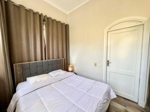a bedroom with a large bed with a gray headboard at Central & Unique 1 BR Apt/ in Downtown @ElGouna in Hurghada +8 photos