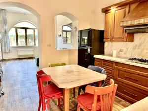 a kitchen with a wooden table and red chairs at Central & Unique 1 BR Apt/ in Downtown @ElGouna in Hurghada