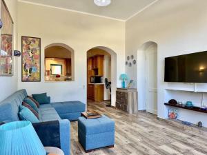 a living room with a blue couch and a tv at Central & Unique 1 BR Apt/ in Downtown @ElGouna in Hurghada