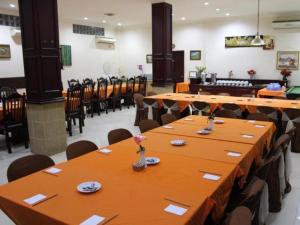 uma sala de jantar com mesas e cadeiras num restaurante em Hotel Dynasty em Sibengkok