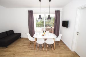 ein Esszimmer mit einem weißen Tisch und Stühlen in der Unterkunft Olive Tree Apartments 2 in Vodice