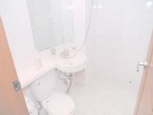 a white bathroom with a toilet and a mirror at Hanbit Pension & Motel in Taean