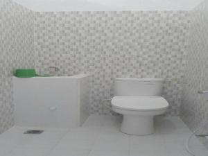 a bathroom with a white toilet and a sink at Hotel Wijaya Magelang in Magelang