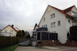 a white house with a fence in a yard at Ferienwohnung Mars FN in Friedrichshafen