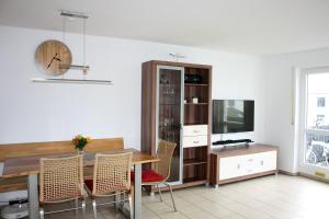 a dining room with a table and chairs and a tv at Ferienwohnung Mars FN in Friedrichshafen