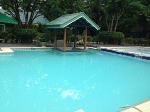 una gran piscina azul con cenador en DJ Paradise Hotel, en Tikay