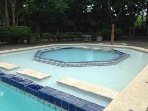 uma grande piscina com azulejos azuis à volta em DJ Paradise Hotel em Tikay
