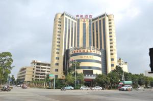 ein großes Gebäude mit davor geparkt in der Unterkunft Kunming Zhong Huang Hotel in Kunming