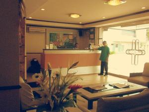 un homme debout à un comptoir dans un salon dans l'établissement Mo2 Days Inn, à Taculing Hacienda