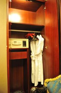 a room with a closet with a robe and a microwave at Kunming Zhong Huang Hotel in Kunming