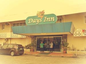 Mo2 Days Inn في Taculing Hacienda: وجود شخصين واقفين خارج النزل اليومي