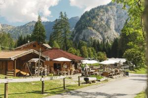 a restaurant with tables and umbrellas in front of a mountain at Camping Marmolada Malga Ciapela - Glamping Experience in Malga Ciapela