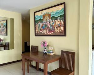 uma mesa de jantar com um quadro na parede em Ponburi Hotel em Nan