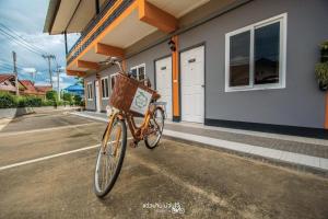 een fiets met een mand geparkeerd voor een huis bij Winhouse Hotel in Nan