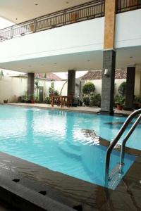 a large blue swimming pool in a building at Hotel Grande Lampung in Lampung