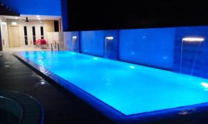una gran piscina con iluminación azul en un edificio en Kiulap Plaza Hotel, en Kampong Serusup