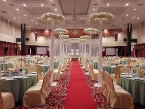 una sala de banquetes con mesas y sillas y una alfombra roja en Kiulap Plaza Hotel, en Kampong Serusup
