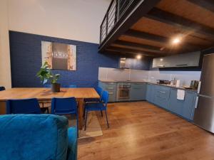a kitchen with a wooden table and blue cabinets at RedCity LOFT 430 in Żyrardów