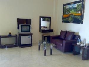 a living room with a couch and a tv at Grand Wisata Hotel in Ende