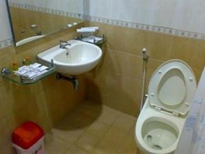 a bathroom with a toilet and a sink at Grand Wisata Hotel in Ende