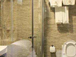 een badkamer met een toilet en een glazen douchedeur bij Guangyuan Hotel Gutian Fujian 