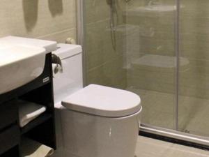 een badkamer met een toilet, een douche en een wastafel bij Guangyuan Hotel Gutian Fujian 