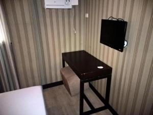 a room with a table with a television on the wall at Starmark Hotel in Naga