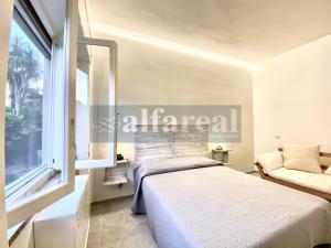 Un dormitorio con una cama y una ventana grande. en Elicriso a pochi passi da spiaggia e dal centro! by Alfareal, en Castiglione della Pescaia