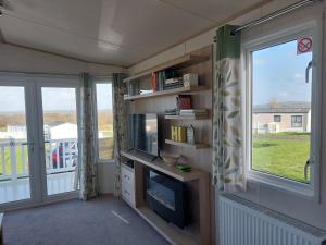 a small living room with a tv and a window at Alphi 4 in Bude