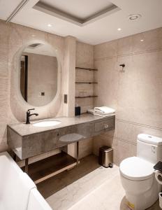 y baño con lavabo, espejo y aseo. en Hotel Yak & Yeti, en Katmandú