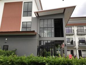 duży biały dom z czarnymi oknami w obiekcie Sabai @ Chumphae Hotel w mieście Chum Phae