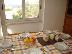 uma mesa com pratos e um cesto de fruta em Lighthouse Villino em Torre Canne