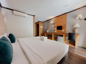 The Hub Erawan Resort في تشونغ ساداو: غرفة نوم مع سرير أبيض كبير ومكتب