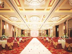 une salle de banquet avec des tables et des chaises dans un bâtiment dans l'établissement Qingdao Huaxi Hotel Laixi, à Laixi