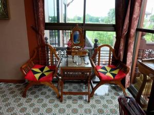 Habitación con 2 sillas y mesa con espejo. en Tai Asean House en Ban Kham Kling