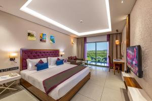 a bedroom with a large bed in a room at Golden Tulip Candolim, Goa in Candolim