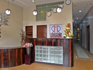a lobby with a counter and clocks on the wall at Rovic's Tourist Hotel in El Nido