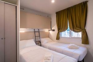 two beds in a small room with a window at La Risacca Family Camping Village in Porto SantʼElpidio