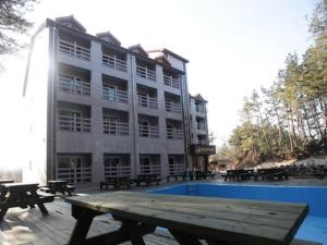 a building with a picnic table in front of a pool at Mangsang Haeorum Family Hotel in Donghae