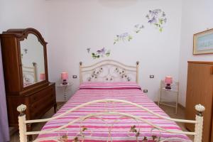 a bedroom with a large bed with a purple blanket at Sant'Anna Bed & Breakfast in Agerola
