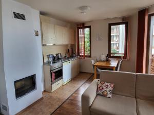 Una cocina y una sala de estar con un sofá y una mesa. en Gri's place, en Bansko
