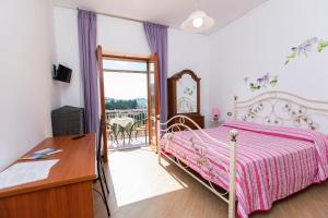 a bedroom with a bed and a desk and a balcony at Sant'Anna Bed & Breakfast in Agerola