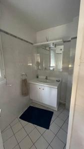 a white bathroom with a sink and a mirror at Beau studio spacieux et calme dans résidence de standing in Boulogne-Billancourt