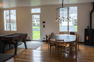 uma sala de jantar com uma mesa de pingue-pongue e uma mesa de pingue-pongue em La maison des gaves - Calme, Agréable, Local vélo em Pierrefitte-Nestalas