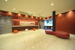 a lobby with a red couch on the floor at Welcome Hotel Kochi in Kochi