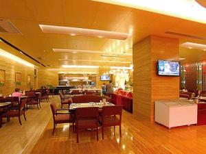 a dining room with tables and chairs and a restaurant at Fuzhou Fuqing Ruixin Hotel in Rongcheng