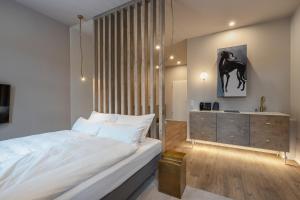 una camera con un grande letto bianco e un comò di kalm stay - a design Aparthotel a Monaco
