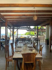 Sunbird Villas في جلاكيه: غرفة طعام مع طاولة وكراسي طويلة