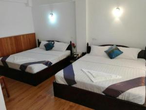 two beds in a small room with at Mya See Sein Hotel in Myeik